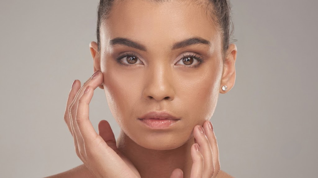 Woman with clear skin touching her face